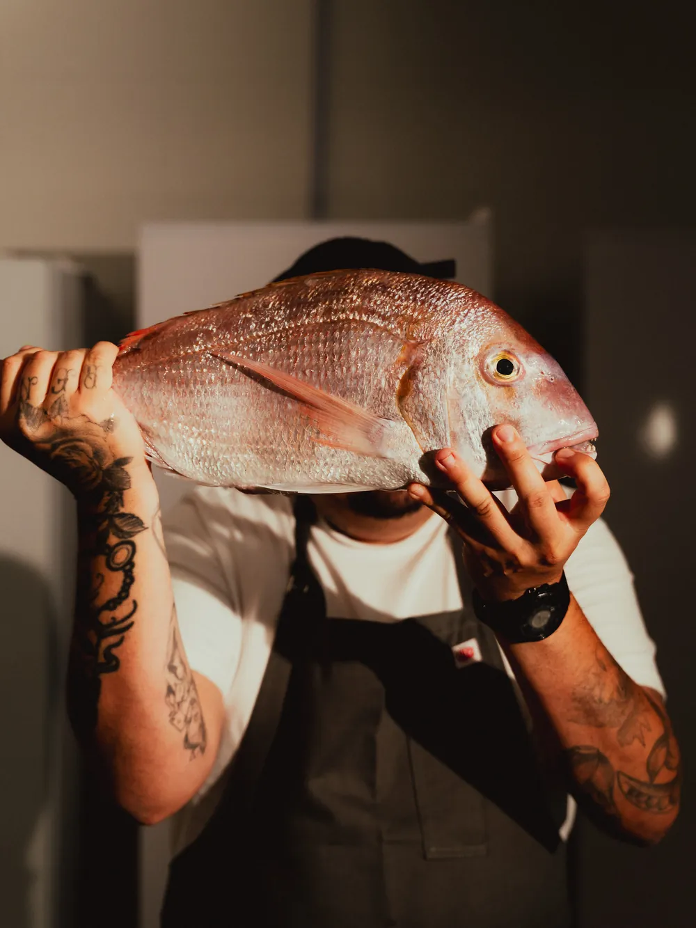 O chef com um pescado do dia nas mãos